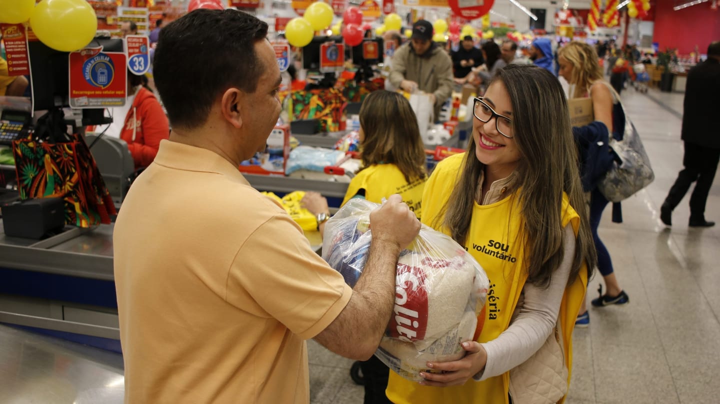 Voluntários arrecadando alimentos em rede de supermercado